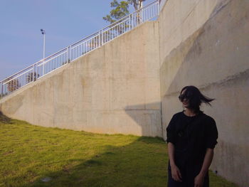 Full length of woman standing against wall