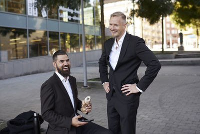 Businessmen eating takeaway lunch outdoors