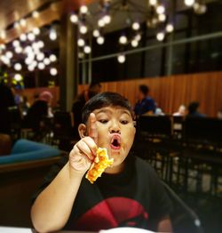 Portrait of boy eating food in restaurant