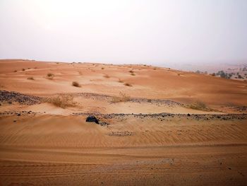 Sand dunes in desert against sky