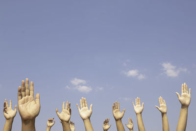 Low angle view of hand against blue sky