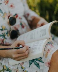 Midsection of woman writing in book