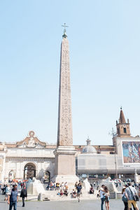 Group of people in front of historical building against clear sky