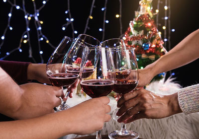 Midsection of friends toasting wineglasses during christmas