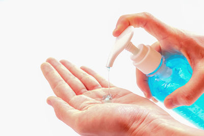 Close-up of woman holding hands over white background