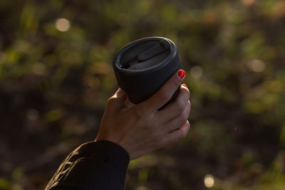 Cropped hand holding camera