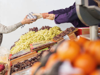 Cropped image of hand holding fruits at market