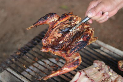 Close-up of person preparing food on barbecue grill