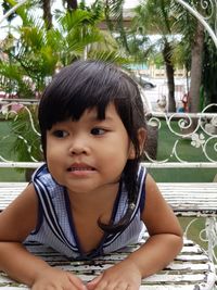 Portrait of cute girl sitting outdoors