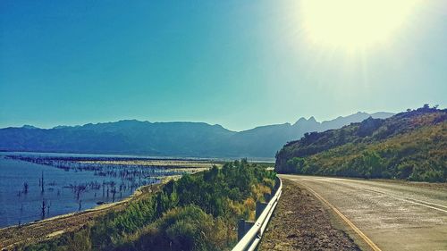 Road leading towards mountains against sky