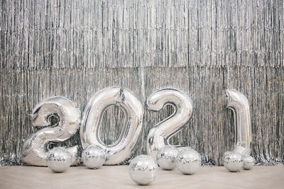 Numbers 2021 from silver colored balls against a silver wall. new year