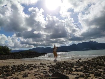 Man standing on beach against sky