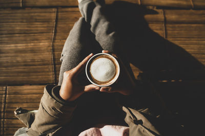 Midsection of man holding coffee cup