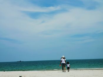 People at beach against sky