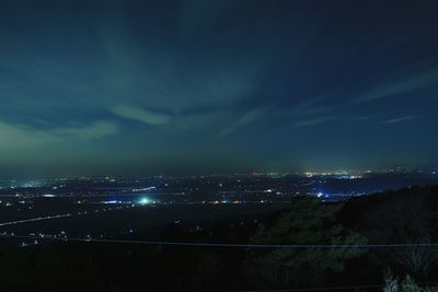 Illuminated cityscape against sky at night