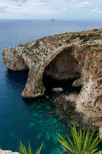 Scenic view of rock formation in sea against sky