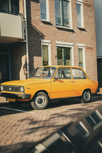 Yellow car on street against building