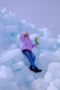 Young woman standing on ice formation