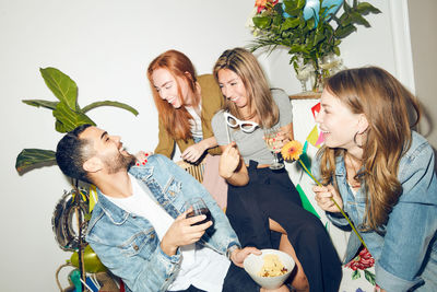 Cheerful young friends enjoying dinner party at home