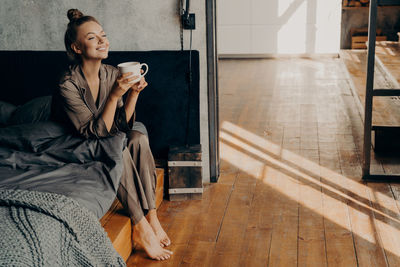 Woman looking at camera while sitting at home