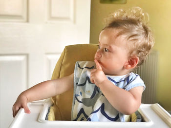 Cute boy looking away while sitting at home