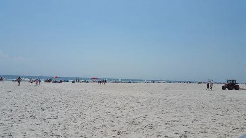 People on beach against clear sky