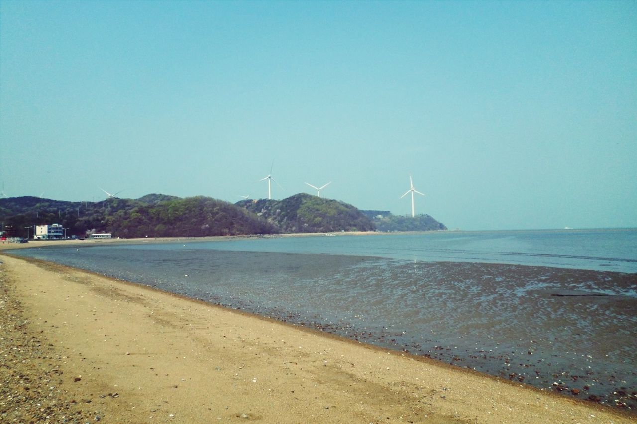 clear sky, copy space, water, sea, tranquil scene, tranquility, blue, beach, scenics, nature, shore, beauty in nature, sand, mountain, transportation, day, coastline, outdoors, idyllic, no people