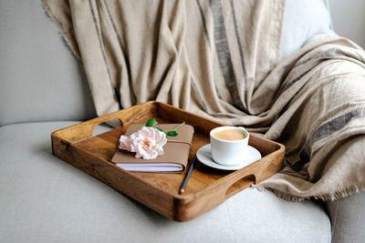 Notepad, pencil and a cup of coffee on a tray.