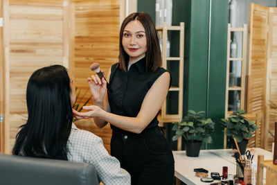 Portrait of a makeup artist girl with a powder brush while working