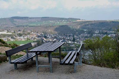 Empty chairs and tables against sky
