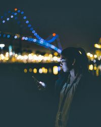 Woman with illuminated lighting equipment at night