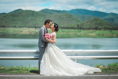 Rear view of couple kissing in water at park