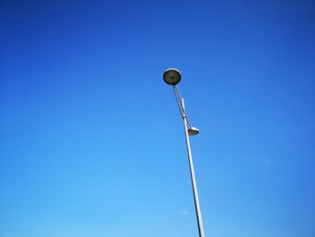 Low angle view of street light against blue sky