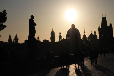 Silhouette of buildings in city at sunset