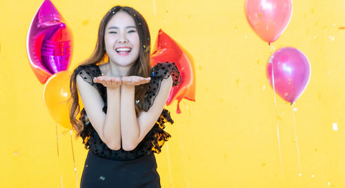 Portrait of a smiling young woman with balloons