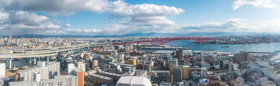High angle view of city buildings against cloudy sky