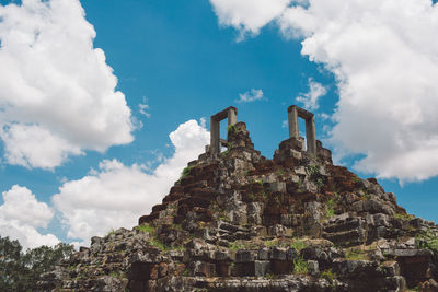 Low angle view of old temple against cloudy sky