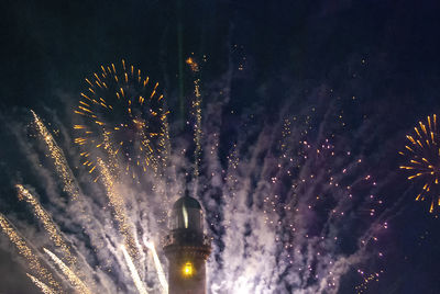 Low angle view of firework display at night