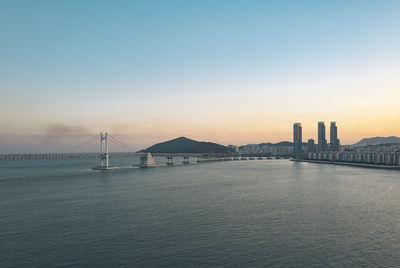 View of suspension bridge in city at sunset