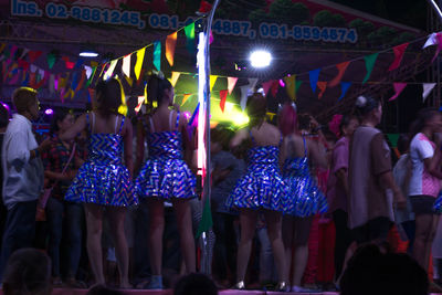 Crowd at illuminated market stall at night