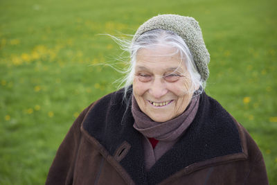 Happy senior woman standing on grassy field