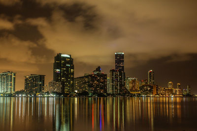 Illuminated buildings in city in the sea