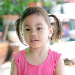 4 years old cute baby asian girl, little child with adorable ponytails smiling looking at camera.