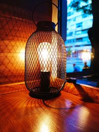 Close-up of illuminated lamp on table