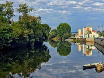 Scenic view of river by trees against sky