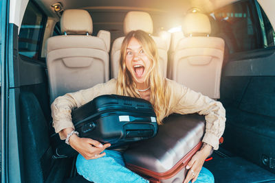Portrait of young woman sitting in car