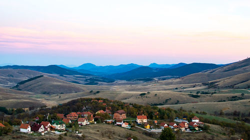 People on landscape against mountains during sunset