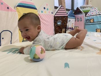 Cute boy lying down on bed at home