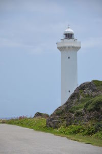 Lighthouse by sea against sky