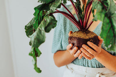 Close up of female hands holding beetroot with leaves